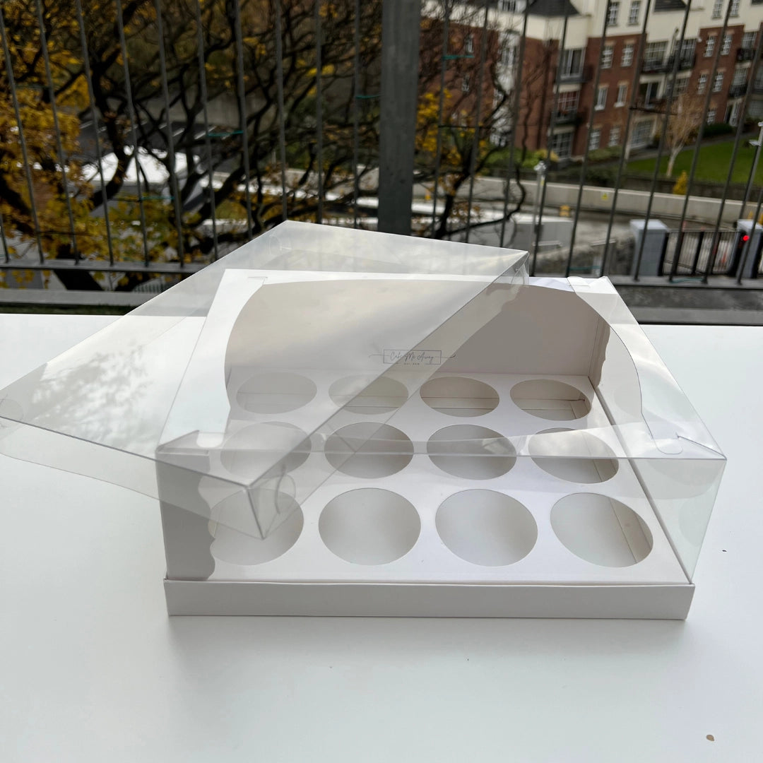 A clear plastic cupcake box with a transparent lid, designed to hold multiple cupcakes. The box has a white base and clear plastic cups for cupcakes, with a visible clear lid.
